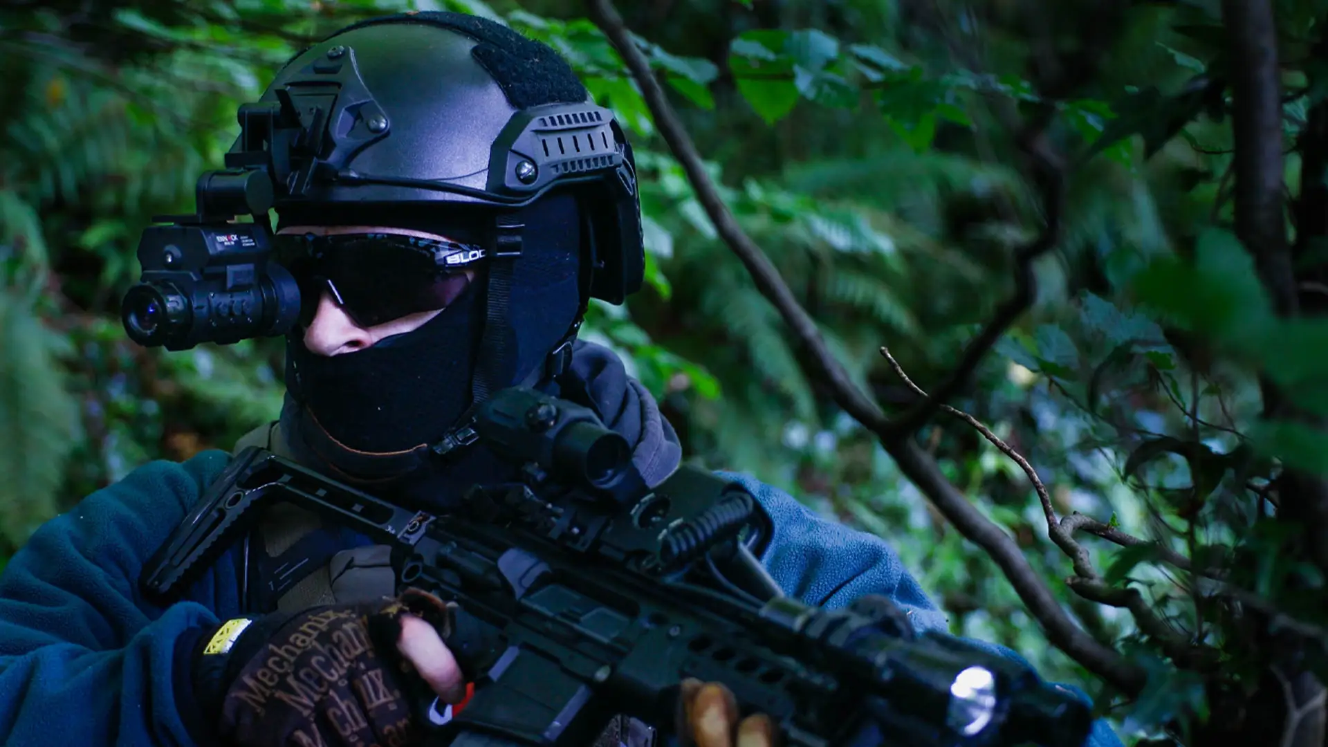 a man wearing a nvg50 digital night vision monocular in the woods